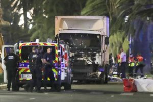 Police officers and rescued workers stand near a van that ploughed into a crowd leaving a fireworks display in the French Riviera town of Nice on July 14, 2016. The mayor of the French city of Nice said dozens of people were likely killed after a van rammed into a crowd marking Bastille Day in the French Riviera resort today and urged residents to stay indoors.  / AFP PHOTO / VALERY HACHE