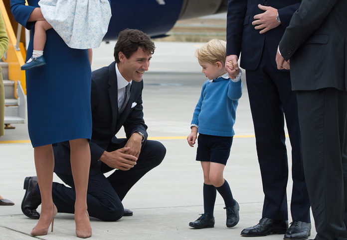 Canadian Prime Minister Justin Trudeau (C) kneels to talk to Prince George as his father Prince William, The Duke of Cambridge, speaks with the Governor General David Johnston (R) and Catherine, The Duchess of Cambridge (C) holds their daughter Princess Charlotte upon arrival at 443 Maritime Helicopter Squadron base on September 24, 2016, in Victoria, British Columbia. The prince and his wife first visited Canada five years ago. This time they will take in the natural beauty of Canada's Pacific coast, heading as far north as the rugged Yukon territory, and will also meet with indigenous people. / AFP PHOTO / The Canadian Press / JONATHAN HAYWARD / RESTRICTED TO EDITORIAL USE - MANDATORY CREDIT "AFP PHOTO / HO/ The Canadian Press/ Jonathan HAYWARD" - NO MARKETING - NO ADVERTISING CAMPAIGNS - DISTRIBUTED AS A SERVICE TO CLIENTS