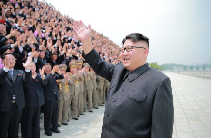 แฟ้มภาพคิม จองอึน ทักทายเจ้าหน้าที่ /  AFP