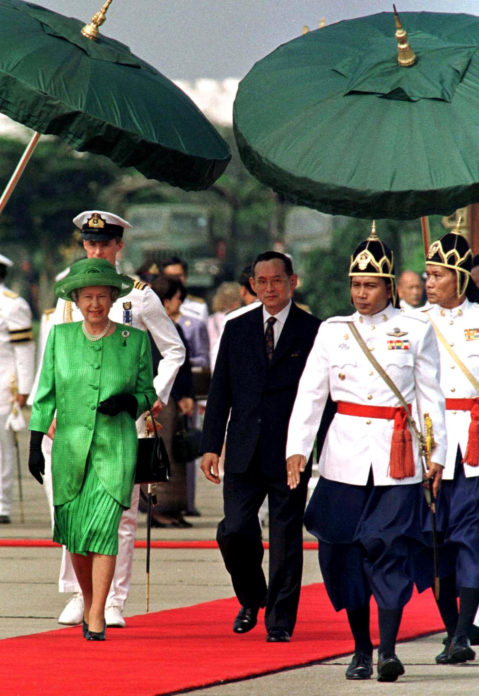 Queen Elizabeth II (L) and Thai King Bhumibol Adulyadej (R) are shaded from the sun during the welcoming ceremony at Bangkok military airport, Thailand October 28, 1996. REUTERS/Dylan Martinez/File Photo