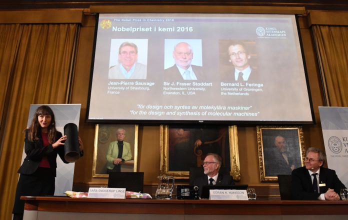 Winners of the 2016 Nobel Chemistry Prize (Up L-R) Jean-Pierre Sauvage, J Fraser Stoddart and Bernard L Feringa are seen on display as (Bottom L-R) Professor of Physical Chemistry and Chairman of the Nobel Committee for Chemistry, Sara Snogerup Linse, Permanent Secretary of the Royal Swedish Academy of Sciences, Goran K Hansson, and Professor Olof Ramstrom react during the official announcement of the 2016 Nobel Chemistry Prize winners at the Royal Swedish Academy of Sciences in Stockholm on October 5, 2016. The / AFP PHOTO / JONATHAN NACKSTRAND