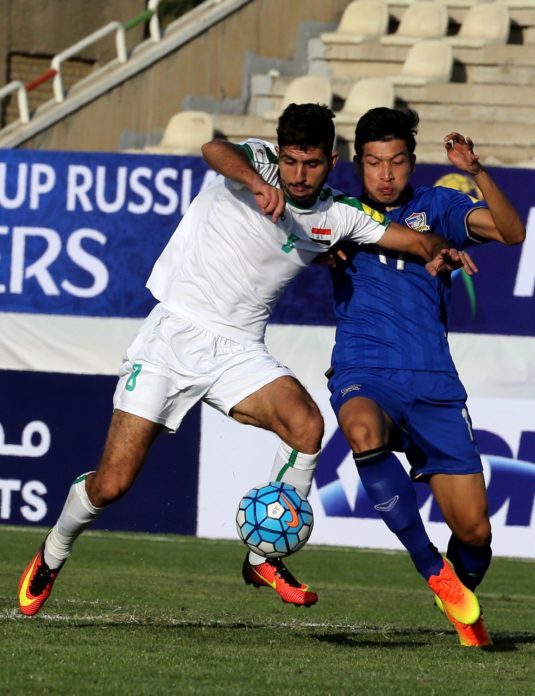 Iraq's Mohannad Abdul-Raheem Karrar (L) is tackled by Thailand's Mongkol Tossakrai (R) during their 2018 World Cup qualifying football match at Shahid Dastgerdi Stadium in the Iranian capital Tehran, on October 11, 2016. / AFP PHOTO / STRINGER