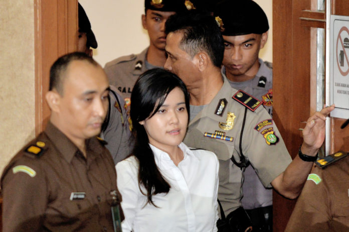 (FILES) In this file photo taken in Jakarta on October 5, 2016 Indonesian murder suspect Jessica Kumala Wongso (C) enters the courtroom prior to her trial at the Central Jakarta court to hear the indictment of the public prosecutor. An Indonesian woman accused of murdering her college friend by slipping cyanide into her coffee broke down in tears on October 12 as she took the stand to deny carrying out the crime. / AFP PHOTO / BAY ISMOYO