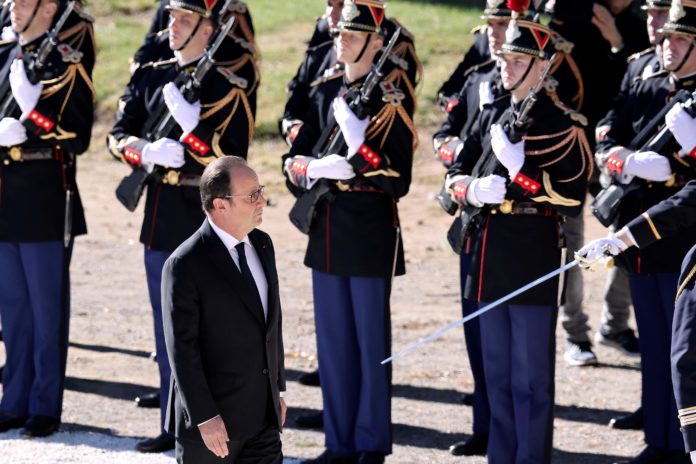 French President Francois Hollande walks past soldiers as he leaves the stage after his speech during a national tribute on October 15, 2016 in Nice, southeastern France in memory of the victims of the July 14 terror attack in which a truck ploughed into crowds celebrating Bastille Day, killing 86 people and injuring more than 400. In the attack, a 31-year-old Tunisian extremist rammed a 19-ton truck through a crowd of more than 30,000 Bastille Day revellers on the seafront Promenade des Anglais before police shot him dead. The Islamic State (IS) group said the driver of the truck, Mohamed Lahouaiej Bouhlel, was one of its followers. / AFP PHOTO / VALERY HACHE