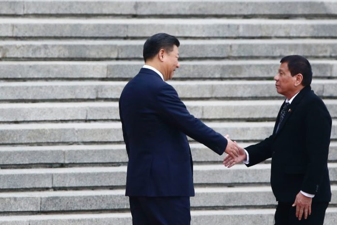 President of the Philippines Rodrigo Duterte (R) and Chinese President Xi Jinping shake hands as they attend a welcoming ceremony at the Great Hall of the People in Beijing, China, October 20, 2016. / AFP PHOTO / POOL / THOMAS PETER