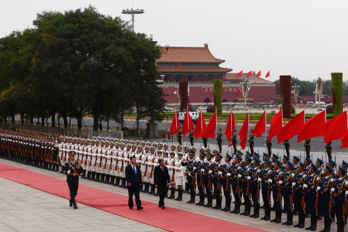 Philippines President Rodrigo Duterte (C) and Chinese President Xi Jinping review the guard of honors as they attend a welcoming ceremony at the Great Hall of the People in Beijing on October 20, 2016. Duterte said it was "time to say goodbye" to the US during a visit to China on October 19, as the combative leader reconfigures his country's diplomatic alliances / AFP PHOTO / POOL AND AFP PHOTO / THOMAS PETER