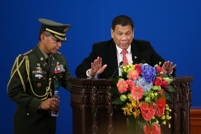 Philippines' President Rodrigo Duterte (R) makes a speech during the Philippines-China Trade and Investment Forum at the Great Hall of the People in Beijing on October 20, 2016. Philippines' President Rodrigo Duterte and his Chinese counterpart Xi Jinping pledged to enhance trust and deepen cooperation October 20, Chinese officials said, as Manila's new leader seeks to rebalance his country's diplomacy away from the US. / AFP PHOTO / POOL / WU HONG