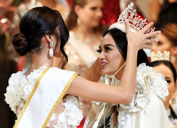 Newly elected 2016 Miss International Kylie Verzosa from Philippines (R) is helped by 2015 Miss International Edymar Martinez from Venezuela (L) during the Miss International beauty pageant final in Tokyo on October 27, 2016. / AFP PHOTO / TOSHIFUMI KITAMURA