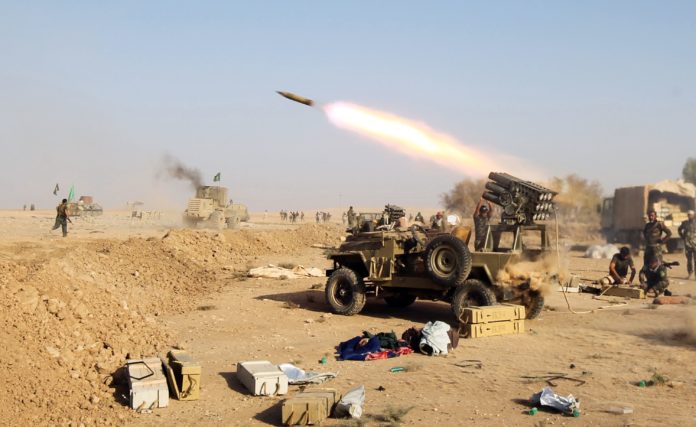 TOPSHOT - Shiite fighters from the Hashed al-Shaabi (Popular Mobilisation) launches missiles on the village of Salmani, south of Mosul, on October 30, 2016 during the ongoing battle against Islamic State group jihadists to liberate the city of Mosul. Iraqi paramilitary forces said they had captured several villages southwest of Mosul from the Islamic State group on Sunday, the second day of an operation to cut the jihadists' supply lines. / AFP PHOTO / AHMAD AL-RUBAYE