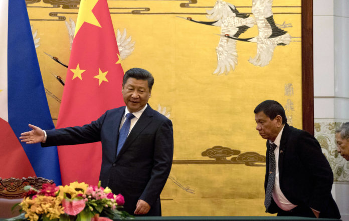 FILE - In this Thursday, Oct. 20, 2016 file photo, Philippine President Rodrigo Duterte, right, is shown the way by Chinese President Xi Jinping before a signing ceremony in Beijing, China.  Japanese officials are wary ahead of the arrival of outspoken Duterte. Their concern is not only about his foreign policy toward the U.S., but also about his informal style. They are paranoid about him chewing gum in front of the Emperor. Duterte arrives in Tokyo later Tuesday for a three-day visit, his first as Philippine leader. (AP Photo/Ng Han Guan, Pool, File)