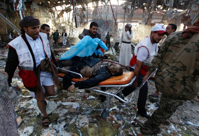 EDITORS NOTE: Graphic content / Yemeni Red Crescent workers carry a victim on a stretcher amid the rubble of a destroyed building following reported airstrikes by Saudi-led coalition air-planes on the capital Sanaa on October 8, 2016. Rebels in control of Yemen's capital accused the Saudi-led coalition fighting them of killing or wounding dozens of people in air strikes on Sanaa. The insurgent-controlled news site sabanews.net said that coalition planes hit a building in the capital where people had gathered to mourn the death of an official, resulting in "dozens of dead or wounded". / AFP PHOTO / MOHAMMED HUWAIS