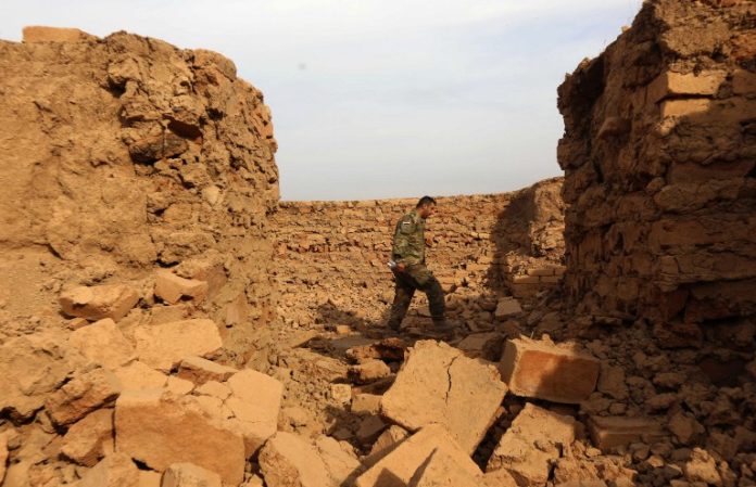 An Iraqi soldier looks at destruction caused by the Islamic State (IS) group at the archaeological site of Nimrud, some 30 kilometres south of Mosul in the Nineveh province, on November 15, 2016, a few days after Iraqi forces retook the ancient city from IS jihadists. Iraqi forces announced that Nimrud, which was founded in the 13th century and became the capital of the Assyrian empire, was recaptured on November 13 as part of the massive operation to retake Mosul, the last IS-held city in the country. / AFP PHOTO / SAFIN HAMED