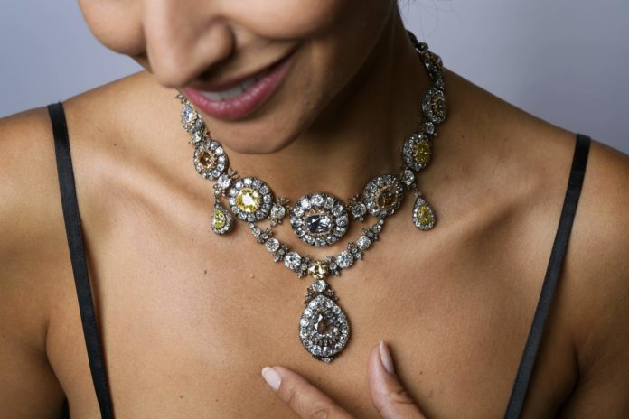 A model poses with a parure of antique coloured diamond jewels during a press preview by Sotheby's auction house on November 9, 2016 in Geneva. The historical necklace part of a gift by Empress Catherine II, known as Catherine the Great (1729  1796), will be offered at a 'Magnificent jewels & noble jewels auction' in Geneva on November 16, 2016 with a pre-sale estimate of US $3-5 million. / AFP PHOTO / FABRICE COFFRINI