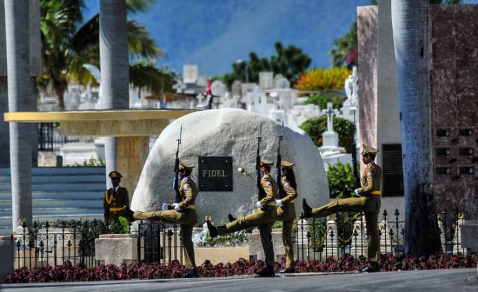 A guard of honour stays by the tomb of Cuban leader Fidel Castro at the Santa Ifigenia cemetery in Santiago de Cuba on December 4, 2016. Fidel Castro's ashes were buried alongside national heroes in the cradle of his revolution on Sunday, as Cuba opens a new era without the communist leader who ruled the island for decades. / AFP PHOTO / AIN / YAMIL LAGE