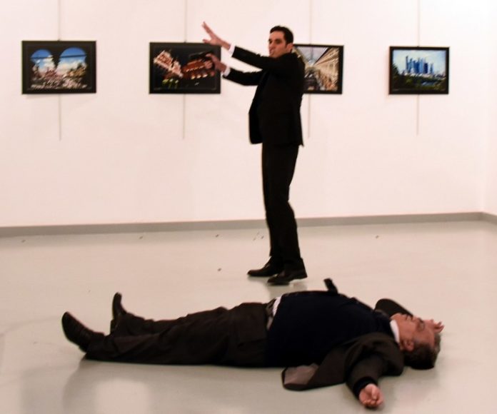 EDITORS NOTE: Graphic content / Andrey Karlov (front), the Russian ambassador to Ankara, lies on the floor next to his killer who still point his gun to people attending an art exhibition in Ankara, on December 19, 2016. A gunman crying "Aleppo" and "revenge" shot Karlov while he was visiting an art exhibition in Ankara on December 19, witnesses and media reports said. The Turkish state-run Anadolu news agency said the gunman had been "neutralised" in a police operation, without giving further details. / AFP PHOTO / STR