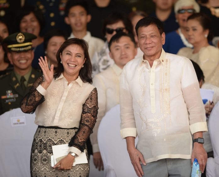  This file photo taken on July 1, 2016 shows Philippines' President Rodrigo Duterte (R) posing for photographs with Vice-President Leni Robredo after the military parade at the military headquarters in Manila./ AFP PHOTO / Ted ALJIBE
