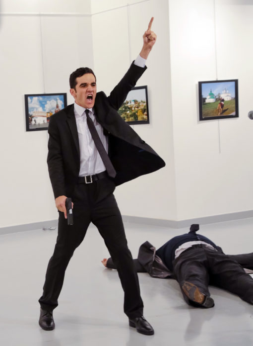An unnamed gunman gestures after shooting the Russian Ambassador to Turkey, Andrei Karlov, at a photo gallery in Ankara, Turkey, Monday, Dec. 19, 2016. A gunman opened fire on Russia's ambassador to Turkey at a photo exhibition on Monday. The Russian foreign ministry spokeswoman said he was hospitalized with a gunshot wound. (AP Photo/Burhan Ozbilici)