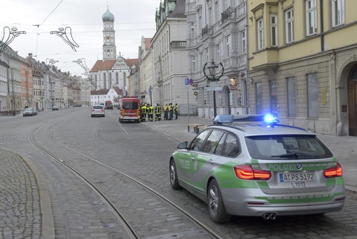 A police vehicle driving through an almost empty street in Augsburg, Germany, Sunday Dec. 25, 2016. Thousands of people in the German town of Augsburg have temporarily left Christmas presents and decorations behind while authorities disarm a World War II bomb. The bomb was uncovered last week during construction work. (Stefan Puchner/dpa via AP)