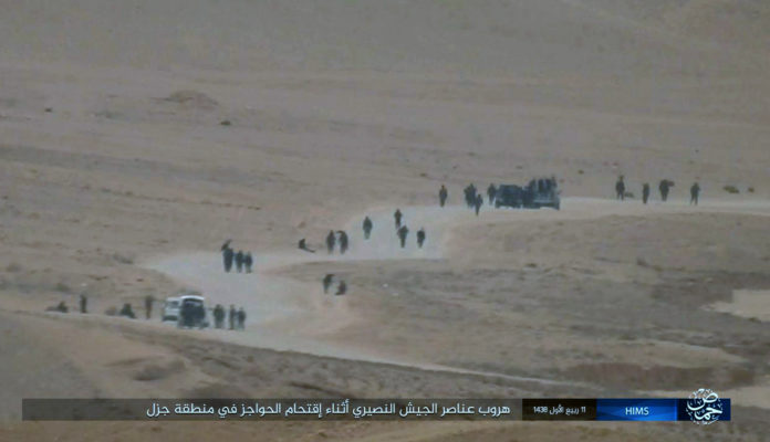 This image posted online on Saturday, Dec. 10, 2016, by supporters of the Islamic State militant group on an anonymous photo sharing website, purports to show Syrian army soldiers fleeing after the group stormed military checkpoints north of Palmyra city, in Homs, Syria. Syrian opposition activists say the Islamic State group has regained control of the ancient town of Palmyra despite a wave of Russian airstrikes in a major advance after a year of setbacks for the group in Syria and Iraq. The Arabic caption reads, "Nussayari (derogative for Alawite Syrian) army soldiers fleeing during the storming of checkpoints in Jazal." (militant photo via AP)