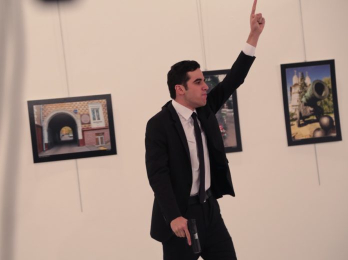 An unnamed gunman gestures after shooting the Russian Ambassador to Turkey, Andrei Karlov, at a photo gallery in Ankara, Turkey, Monday, Dec. 19, 2016. A gunman opened fire on Russia's ambassador to Turkey at a photo exhibition on Monday. The Russian foreign ministry spokeswoman said he was hospitalized with a gunshot wound. (AP Photo/Burhan Ozbilici)