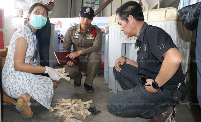 เจ้าหน้าที่กำลังตรวจสอบกระดูกที่พบในเครื่องซักผ้า