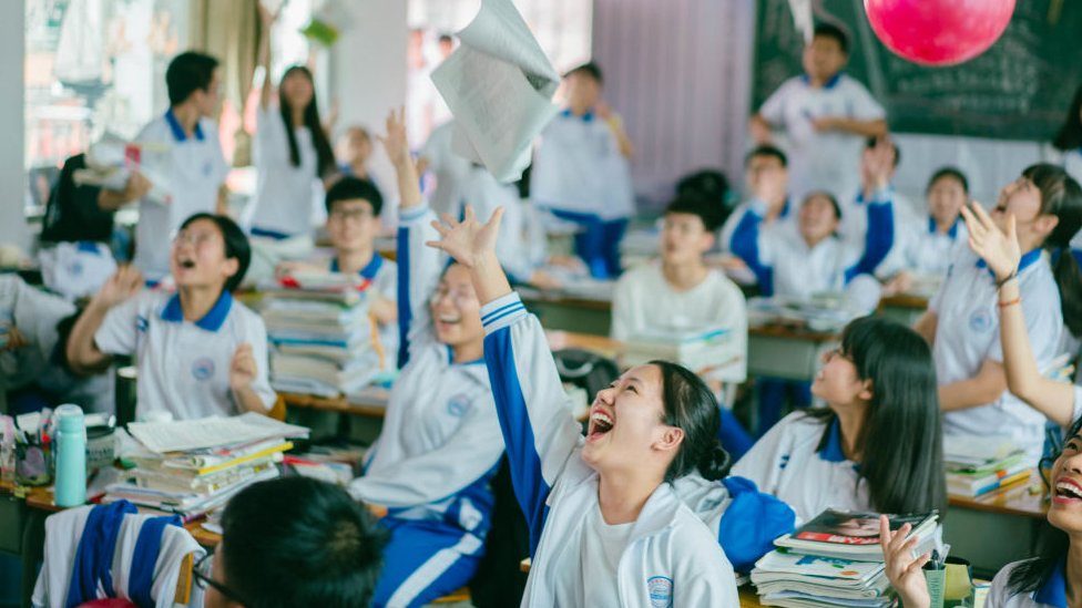นักเรียนโยนกระดาษไปในอากาศ