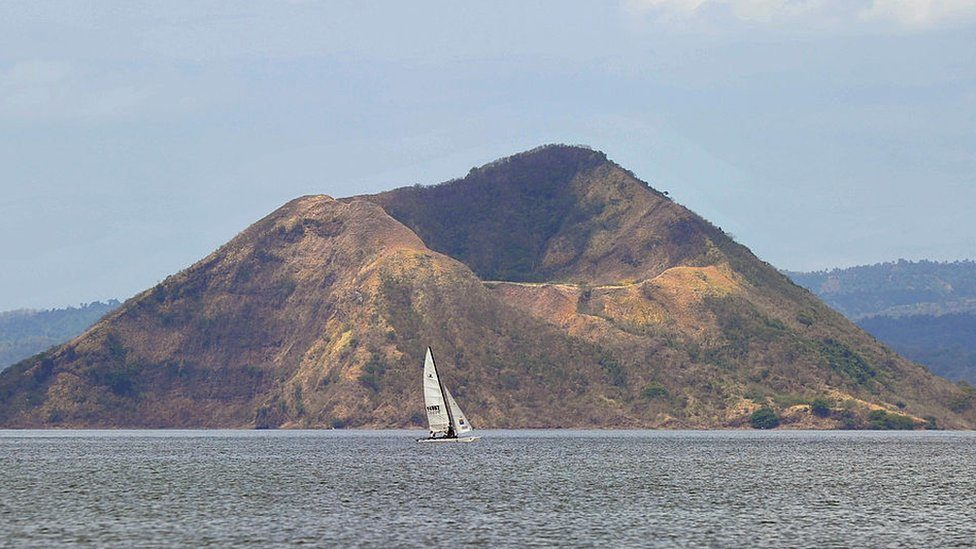 Tourists sail past the volcanic crater locally known as Binintiang Malaki (big extended leg), part of the Taal volcano islan