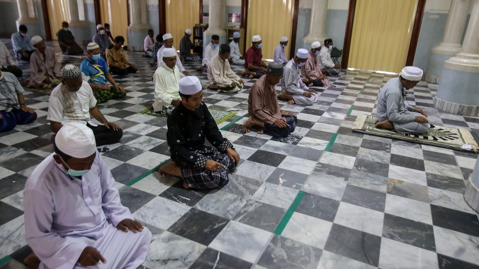 Muslim men practise social distancing as a preventive measure against the spread of the COVID-19 novel coronavirus as they take part in prayers at a mosque in Pattani on March 27, 2020