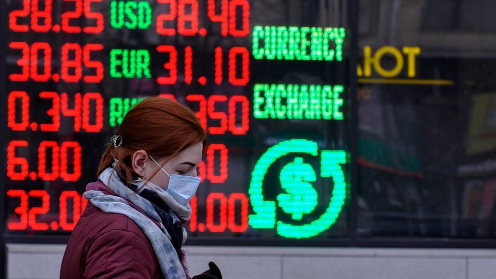 A woman walks past a money exchange shop