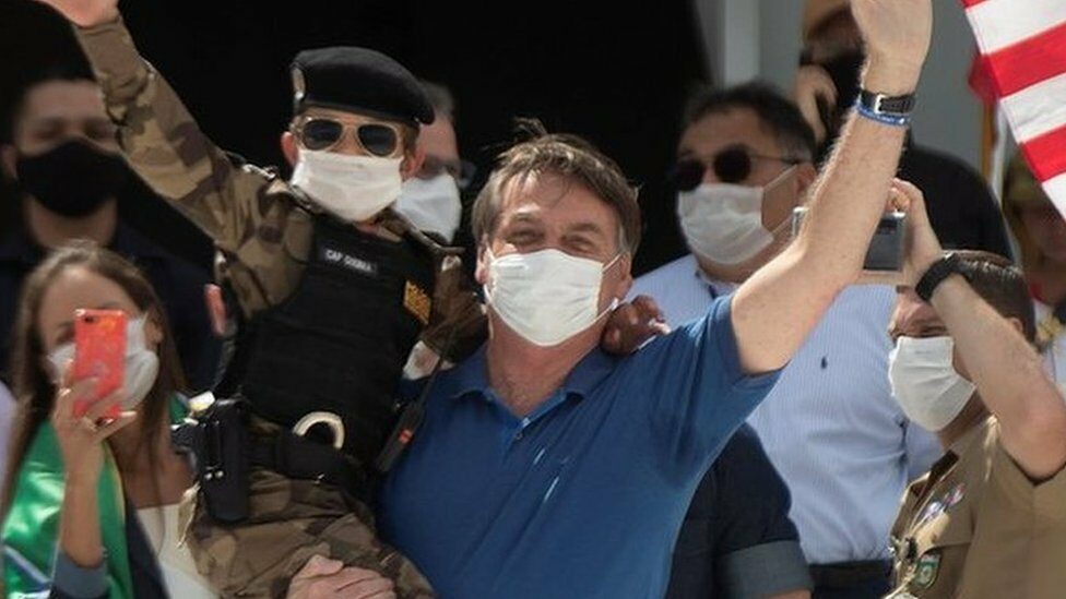 Brazilian President Jair Bolsonaro (C) attends a rally with supporters in Brasilia