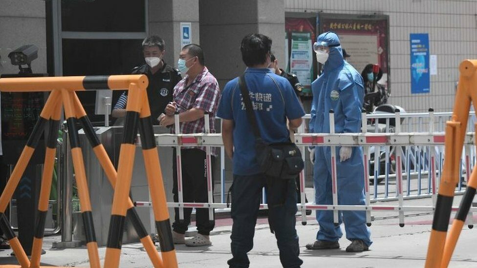 Security guards at a residential area under restrictions near Yuquan East Market in Beijing