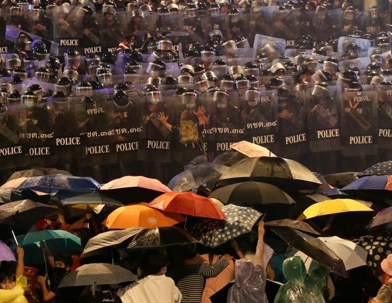 Pro-democracy protesters face riot police during an anti-government protest in Bangkok, Thailand, 16 October 2020