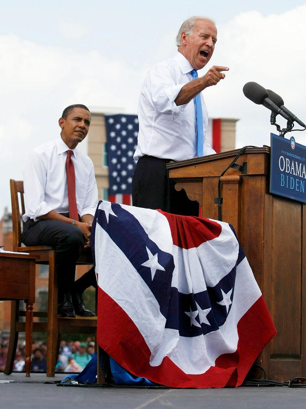 Barak Obama listens Joe Biden on stage
