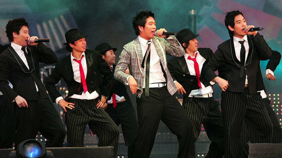 MC Mong on stage surrounded by backing singers