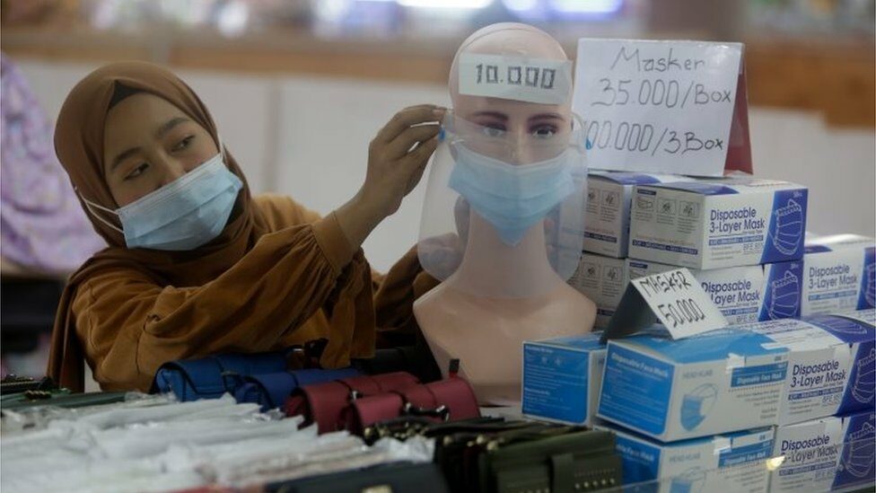 A vendor arranges a mask attached to a mannequin at a shopping mall in Jakarta, Indonesia, 04 January 2021.