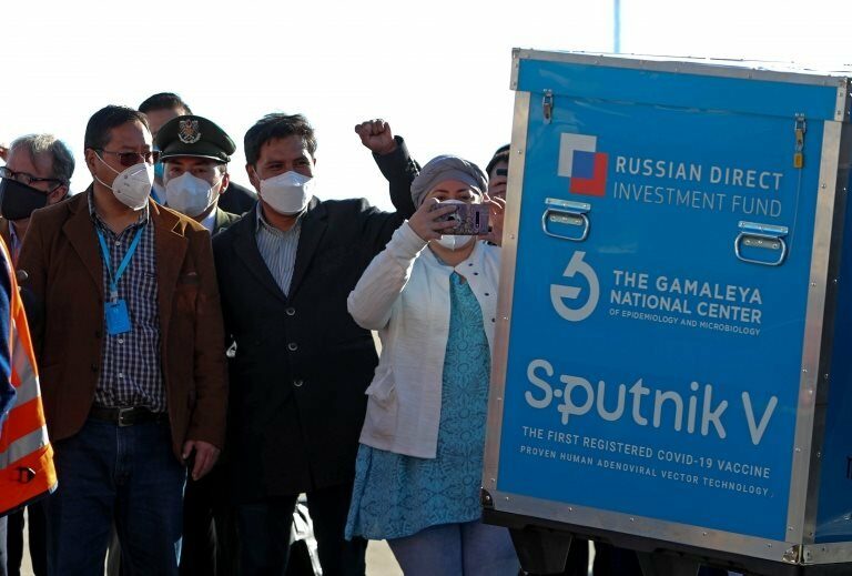 Bolivian President Luis Arce (L) observes a container with doses of Russian vaccine Sputnik V, at International Airport of El Alto, Bolivia, 28 January 2021. Bolivia received the first lot of 20,000 doses of the Sputnik V vaccine