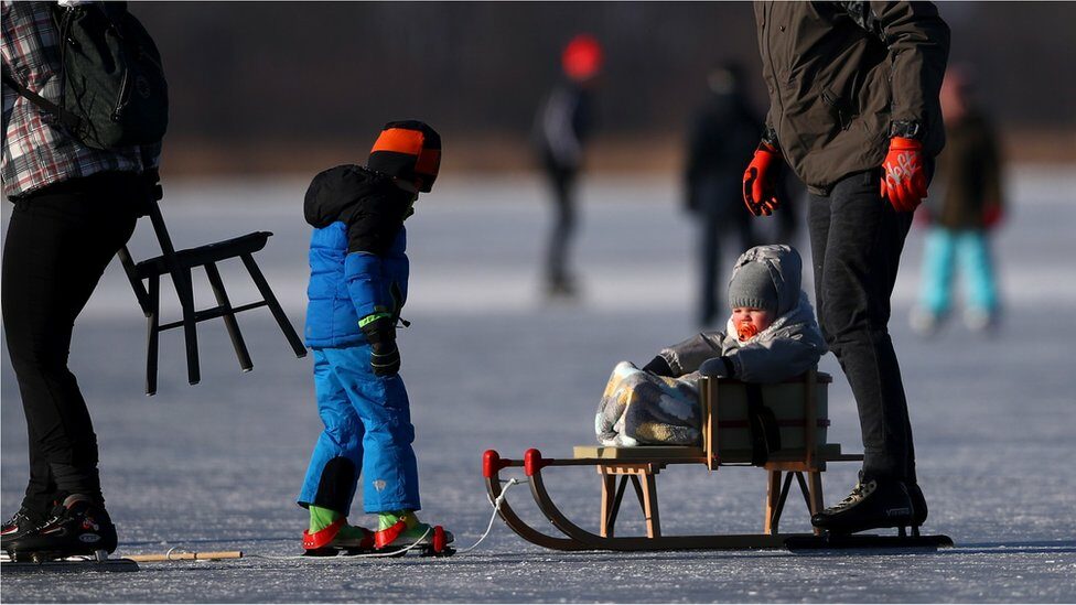 People skate on the Nannewiid, a lake frozen over as temperatures stay below zero and locals enjoy activities like speed skating, ice hockey, using sleds and walking dogs on February 12, 2021 in Oudehaske, Netherlands.