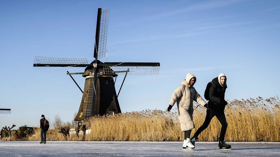 Skaters on the ice pass the windmills in Kinderdijk, The Netherlands, 13 February 2021.