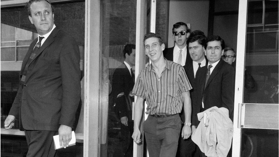 Stiff and limping: Brian Robson on his arrival back at Heathrow