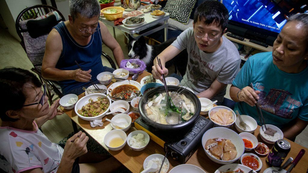 A family partakes in a steamboat meal for their reunion dinner at home on the eve of the lunar new year on 11 February 2021 in Singapore.