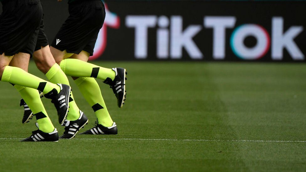 footballers legs and TikTok logo