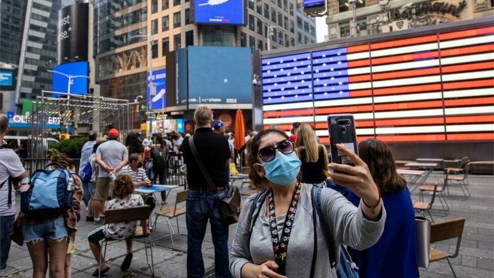 People watch the launch of Blue Origin"s inaugural flight to the edge of space, on a screen in Times Square in New York