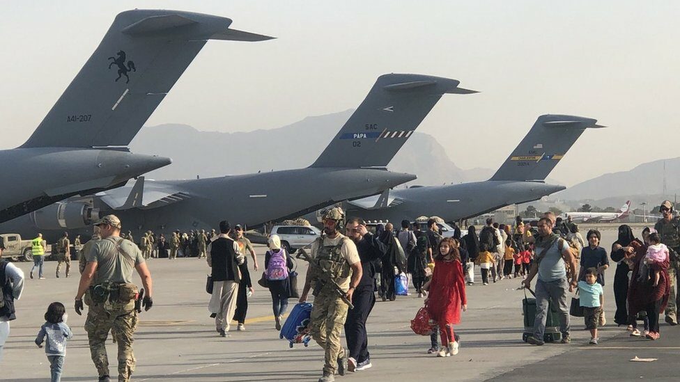 Gente caminando en un avión C-17.  P. en el aeropuerto de Kabul
