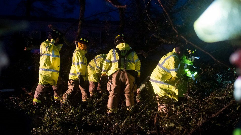 Firefighters clear trees from the road in Bourg, southern Louisiana