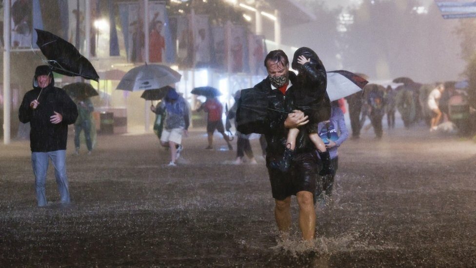 People navigate heavy rains and flooded walkways at the Billie Jean King National Tennis Center as the remnants of Hurricane Ida hit the area in Flushing Meadows, New York, USA, 01 September 2021.