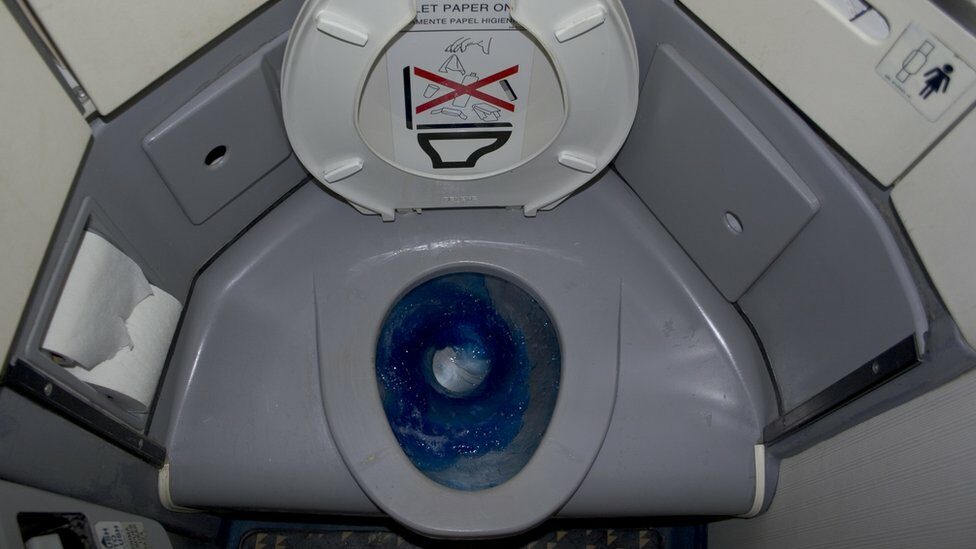 An aeroplane toilet showing blue disinfectant