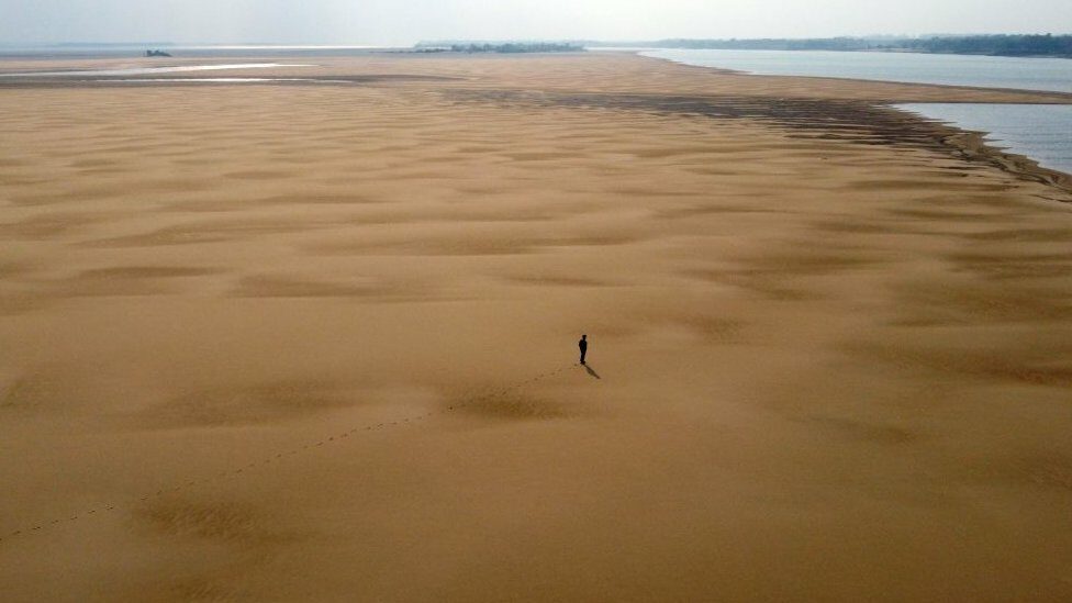 In this aerial view environmentalist Luis Martinez walks along a sand bank at the Parana River, during a historic drought, near Paso de la Patria, Corrientes, Argentina, on August 20, 2021.
