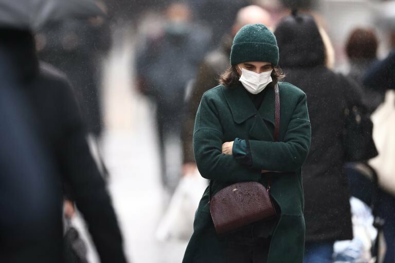 A woman, wearing a protective mask, walks on Montorgueil street in Paris amid the coronavirus disease (COVID-19) outbreak in France, December 3, 2021.