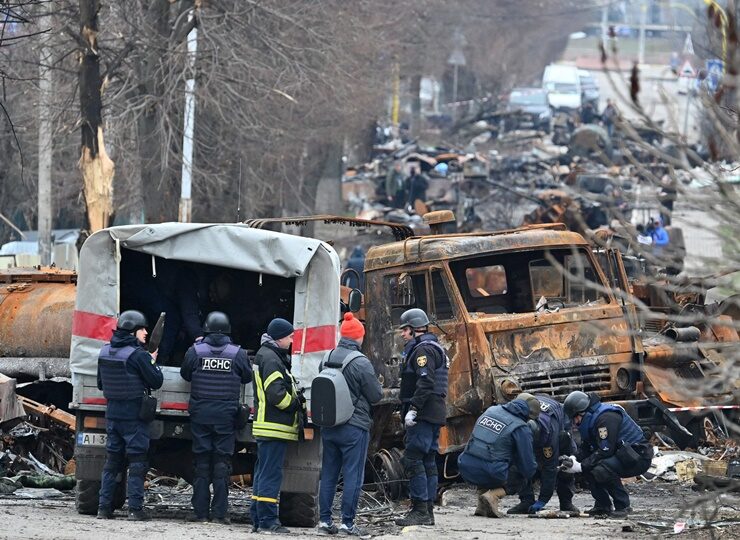 ield engineers of the State Emergency Service of Ukraine conduct mine clearing among destroyed vehicles on a street of Buch.