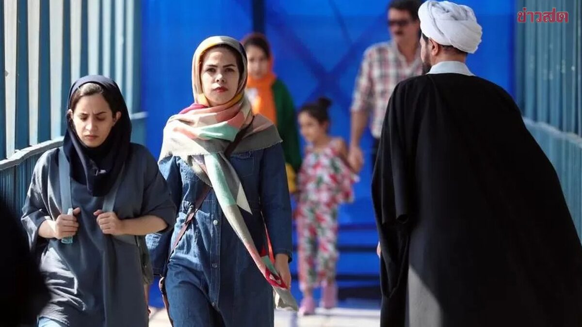 Iranian women walk past a cleric in a street, in Tehran, Iran, 19 September 2022